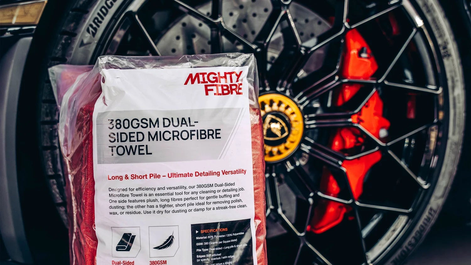 Mighty Fibre 380GSM dual-sided microfiber towel packaging in front of a car wheel.